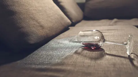 Copa de vino derramada en el sof&aacute;