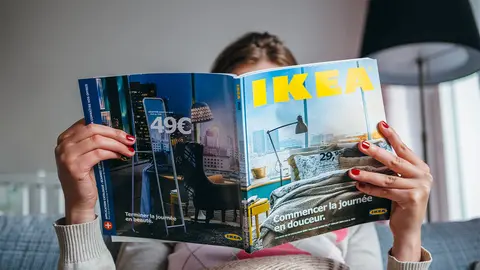 Mujer en su sof&aacute; con el cat&aacute;logo de IKEA