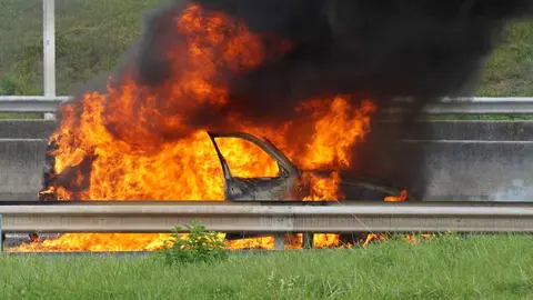 Un coche en llamas en una foto de archivo