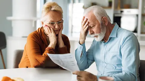 Pareja de pensionistas preocupados leyendo un documento de la Seguridad Social