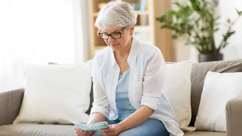 Una pensionista cuenta el dinero recibido tras la &uacute;ltima subida de la Seguridad Social