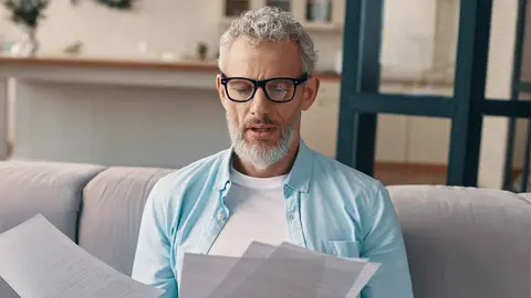 Un pensionista revisa documentos de la Seguridad Social