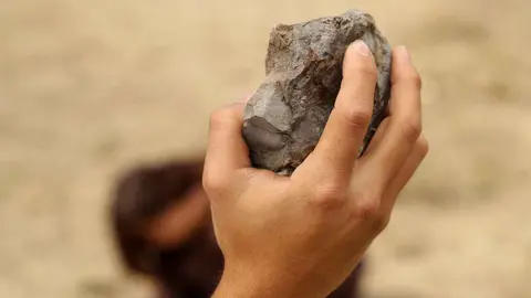 Un hombre con una piedra en la mano
