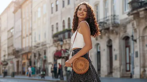 Mujer luce feliz paseando por la ciudad