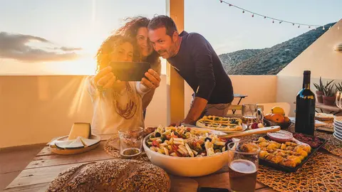 Grupo de amigos durante una comida en la terraza de su casa