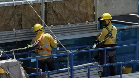 Dos obreros trabajan en una obra