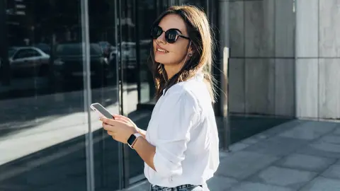 Mujer de negocios exitosa que usa un iPhone 12 Pro y un Apple Watch