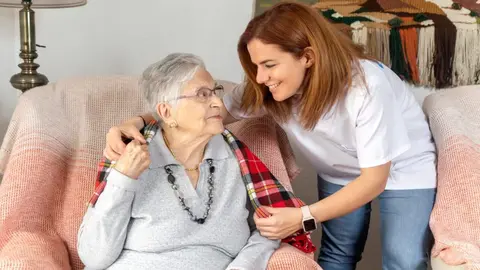 Una trabajadora atiende a una se&ntilde;ora en su domicilio