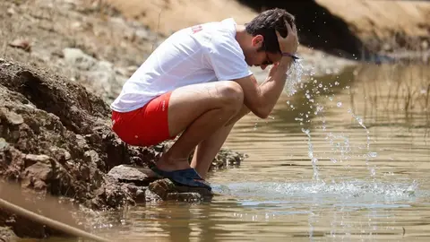 Un hombre se refresca en un pantano