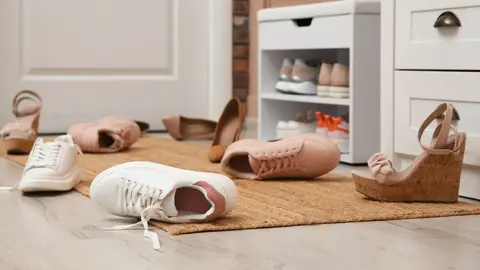 Desorden de calzado en la entrada de casa