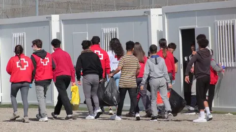 Un grupo de menores extranjeros, acompa&ntilde;ados por voluntarios de la Cruz Roja, llegan a un albergue