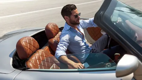 Hombre rico en coche de alta gama descapotable