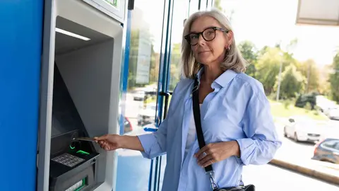 Una pensionista de la Seguridad Social sacando dinero del banco