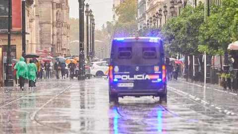 Polic&iacute;a Nacional en Avenida de la Constituci&oacute;n en un d&iacute;a de lluvia en Sevilla | Salvador L&oacute;pez Medina para El MIRA