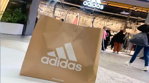 Bolsa de compra Adidas frente a su tienda