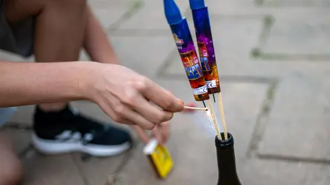 Una persona enciende un petardo