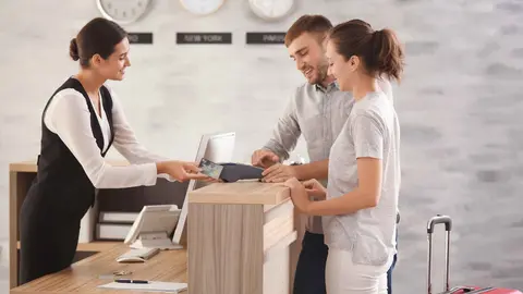 Turistas en la recepci&oacute;n de un hotel