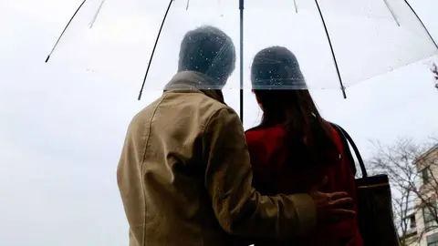 Dos personas con un paraguas bajo la lluvia
