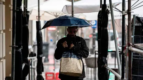 Una persona se protege de la lluvia con un paraguas