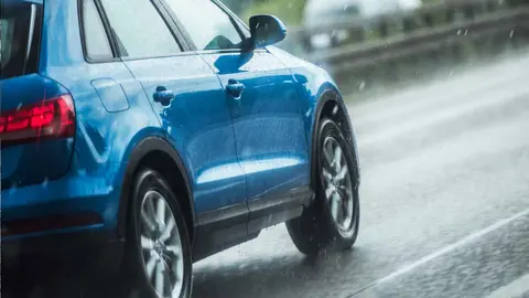 Un coche circulando bajo la lluvia