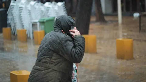 Una persona caminando bajo la lluvia por Sevilla