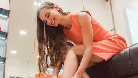 Mujer se coloca una botas en la secci&oacute;n de calzado