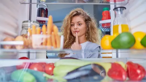 Mujer observa interior de la nevera