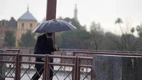 Un hombre paseando bajo la lluvia