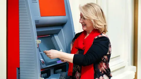 Una pensionista retira dinero del cajero