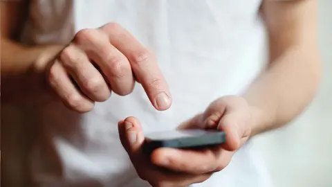 Un joven con un m&oacute;vil