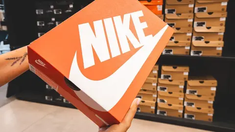 Mujer sostiene una caja de zapatillas NIKE