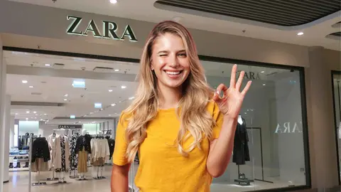 Una mujer a la moda frente a una tienda de Zara