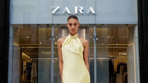 Una mujer a la moda frente a una tienda de Zara