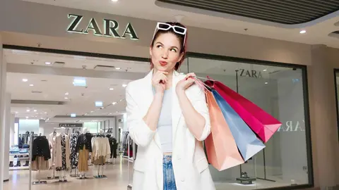 Una mujer a la moda frente a una tienda de Zara