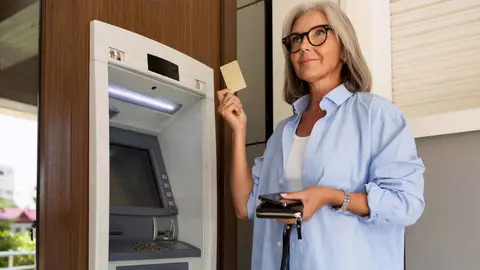 Una pensionista retira el dinero de su pensi&oacute;n en una sucursal bancaria