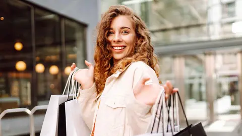 Una mujer con bolsas de compra de una tienda de moda