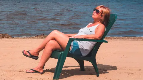 retired woman on vacation sitting at the beach Maskinonge Lake St-Gabriel-de-Brandon Quebec Canada