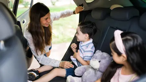 Una madre con sus hijos en el coche