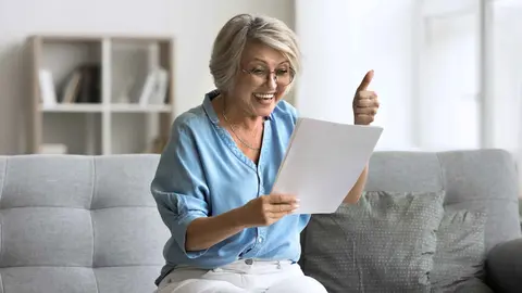 Una pensionista de la Seguridad Social comprueba el cheque a cobrar en 2026