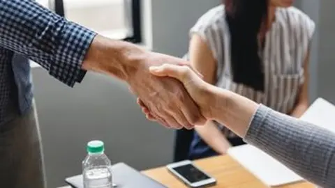 Imagen de dos personas estrechando la mano tras un acuerdo