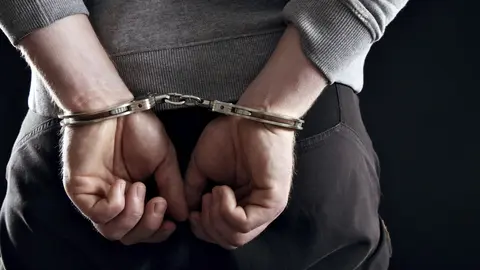 Outlaw's Hands Locked in Handcuffs