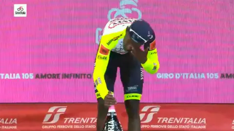 Biniam Girmay, instantes desp&uacute;es de golpearse el ojo con el tap&oacute;n de la botella de champagne.