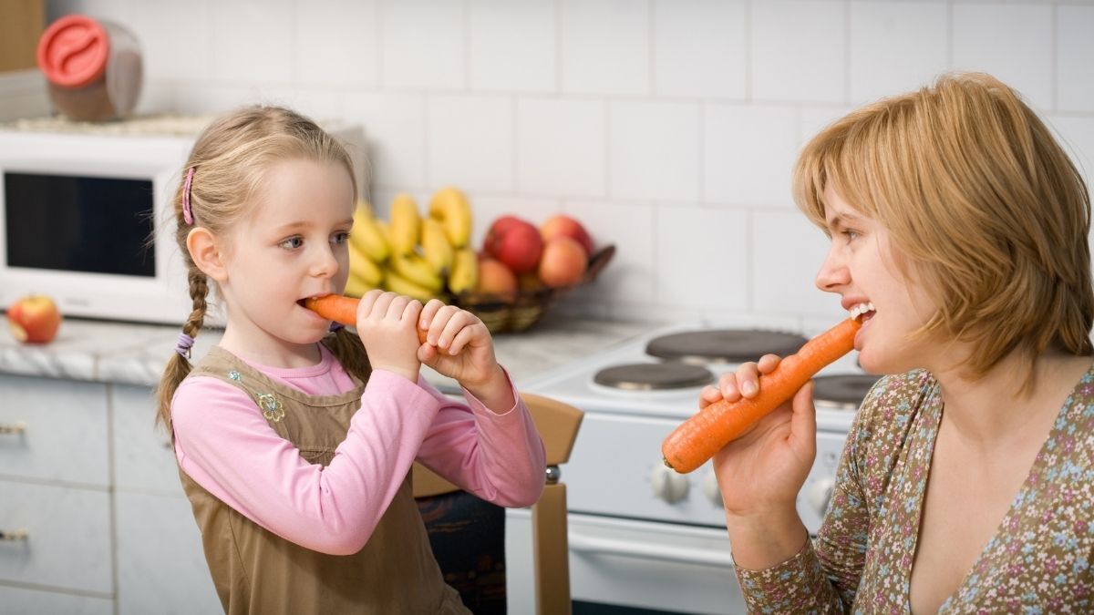 Madre y niña comen zanahoria