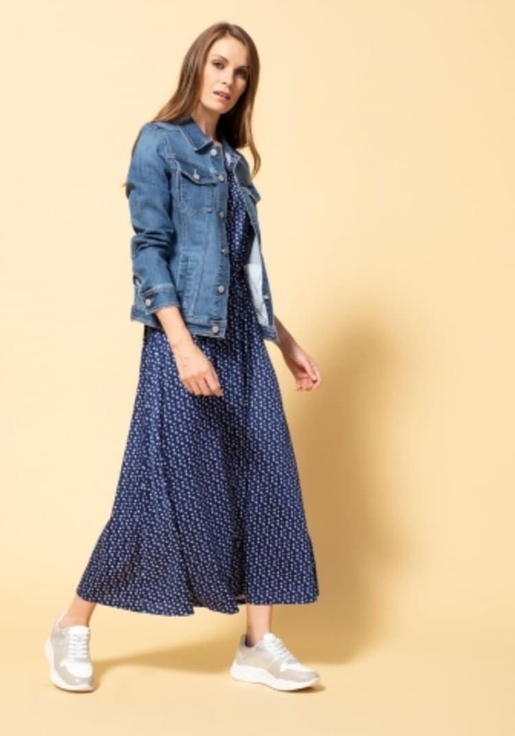 Look de vestido largo, cazadora vaquera y zapatos de deporte