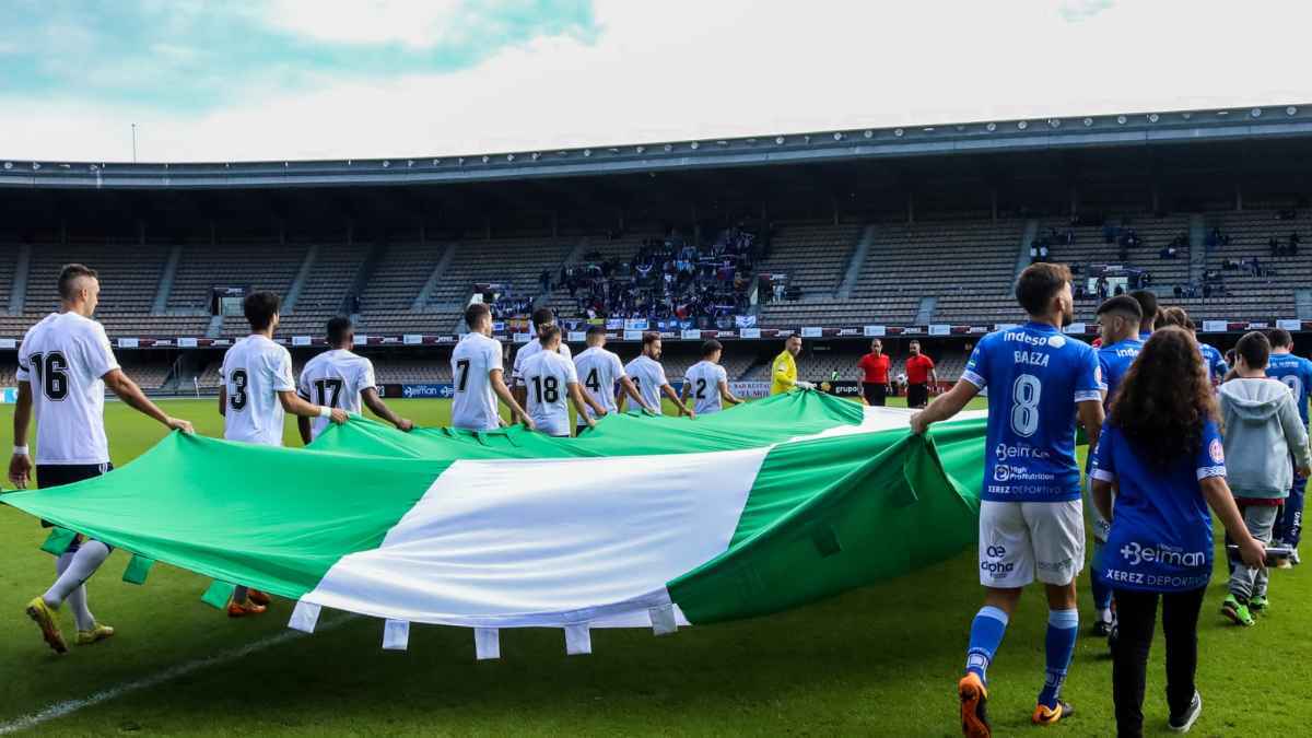 Jugadores del Xerez Deportivo FC y Recreativo de Huelva portando la bandera de Andalucía en Chapín