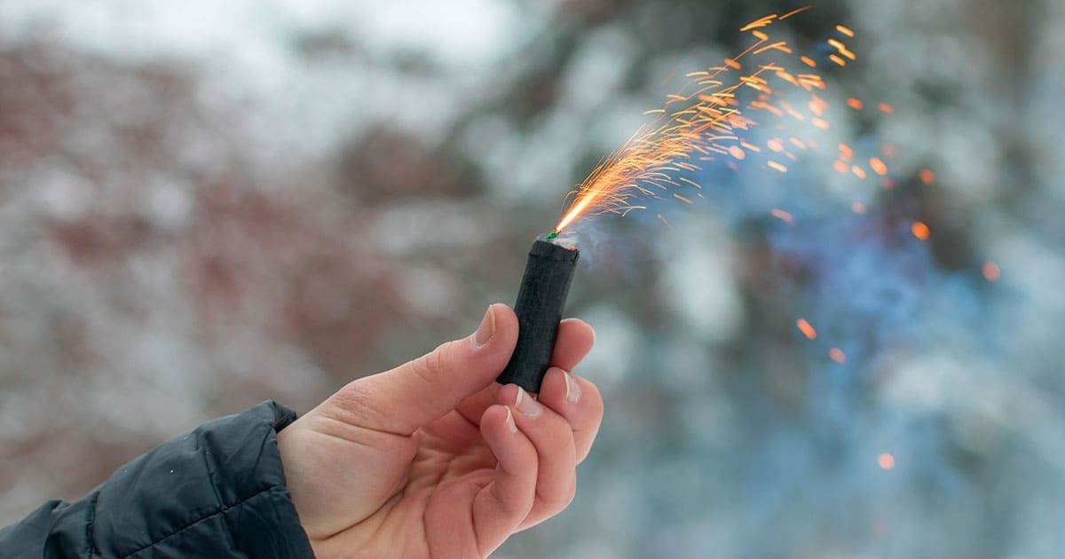 Una persona enciende un petardo durante una pasada Nochevieja