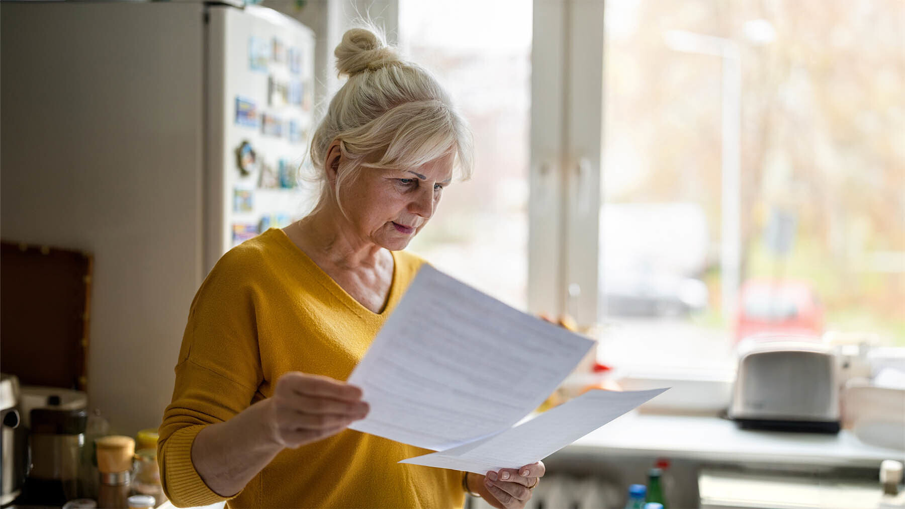 Mujer revisa documentación en la cocina