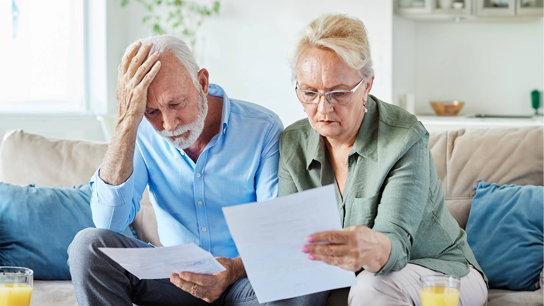 Pareja de pensionistas se muestran preocupados con documentación sobre sus pensiones y finanzas