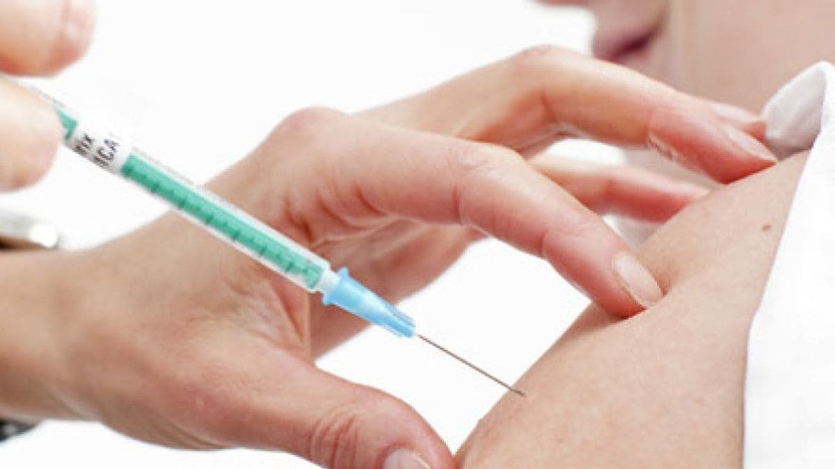 Un joven mientras se le inyecta la vacuna