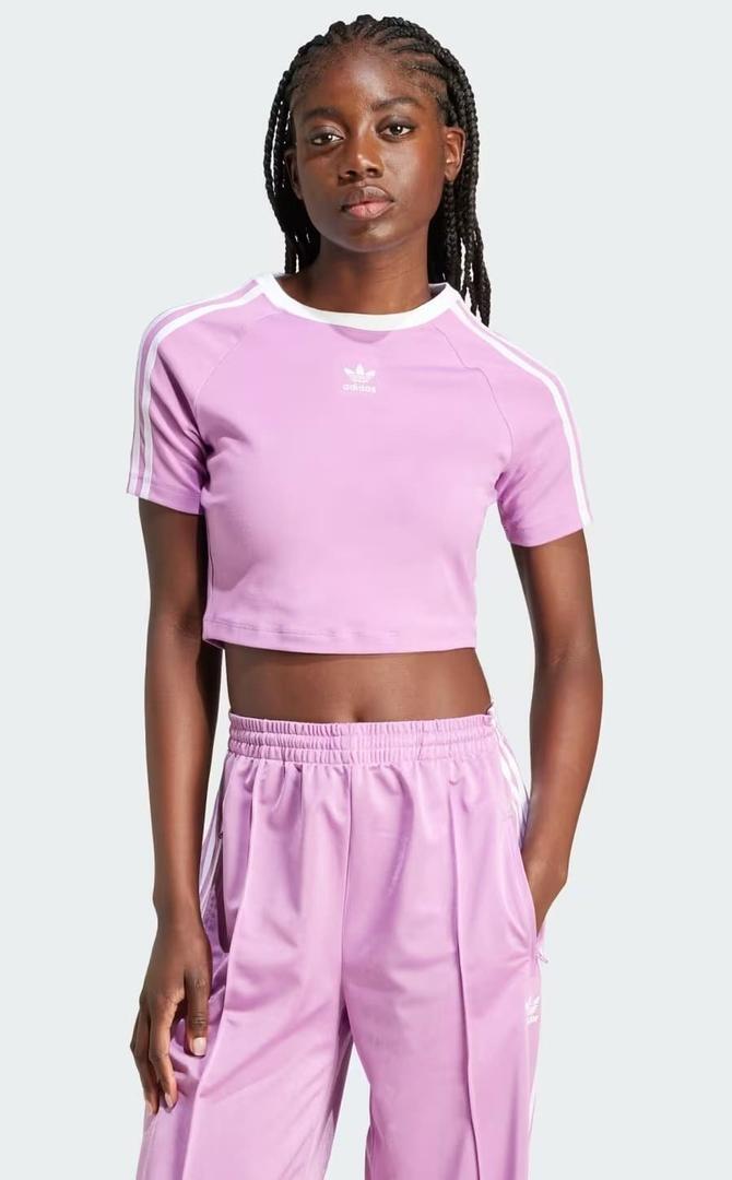 La nueva camiseta baby con tres bandas de color rosa de Adidas